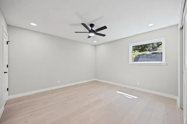an empty room with window and a ceiling fan
