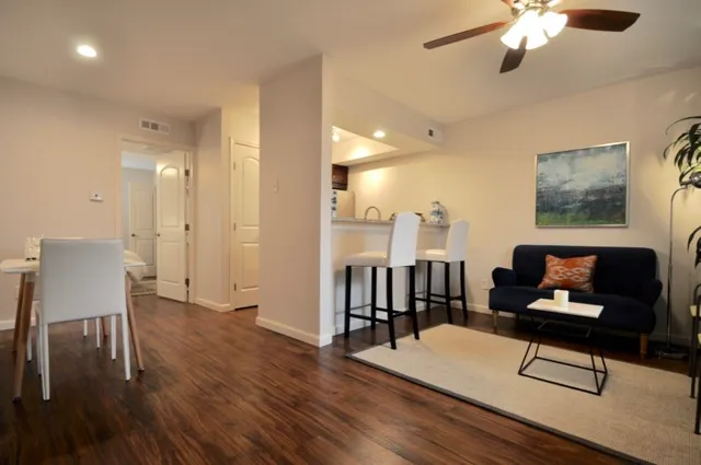 a living room with furniture and a wooden floor