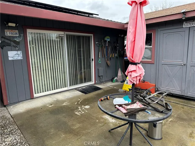 a backyard with a table and chairs and a barbeque