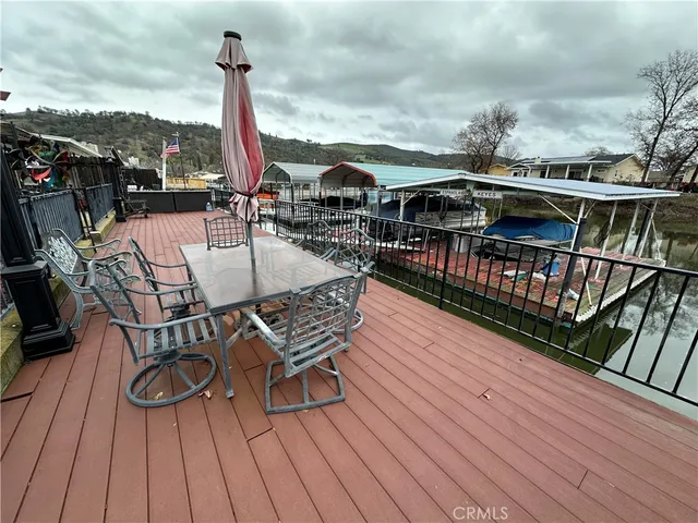 a view of a roof deck with table and chairs a barbeque with wooden floor