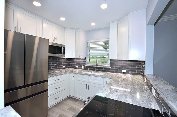 a kitchen with a sink a refrigerator and cabinets