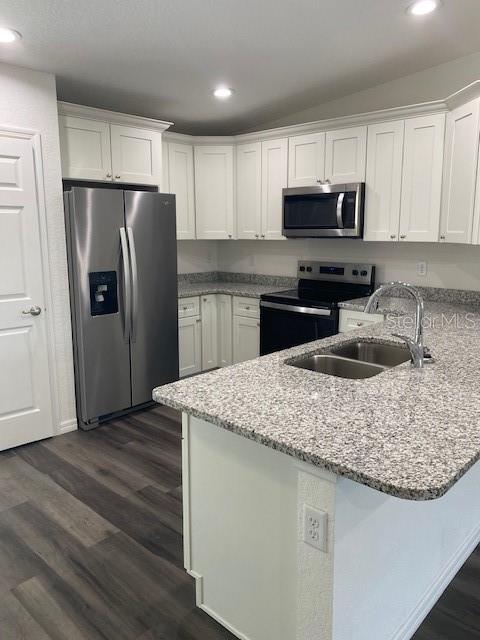40 Maple Lane Ocklawaha, FL 32179 - Photo 19 of 50 a kitchen with kitchen island a sink dishwasher a refrigerator and wooden cabinets