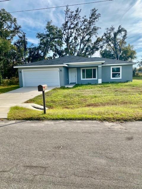 40 Maple Lane Ocklawaha, FL 32179 - Photo 2 of 50 a front view of a house with a garden and yard