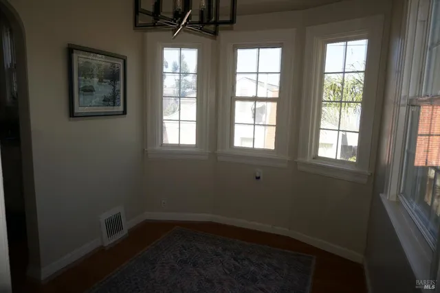 a view of a hallway with wooden floor and cabinets