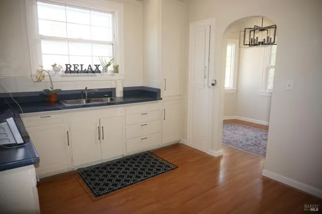 a kitchen with granite countertop white cabinets and a sink