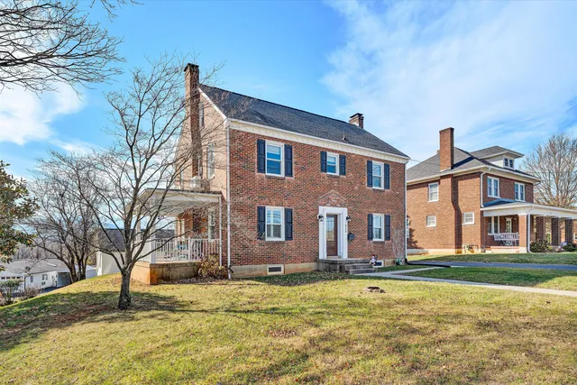 a front view of residential houses with yard and trees