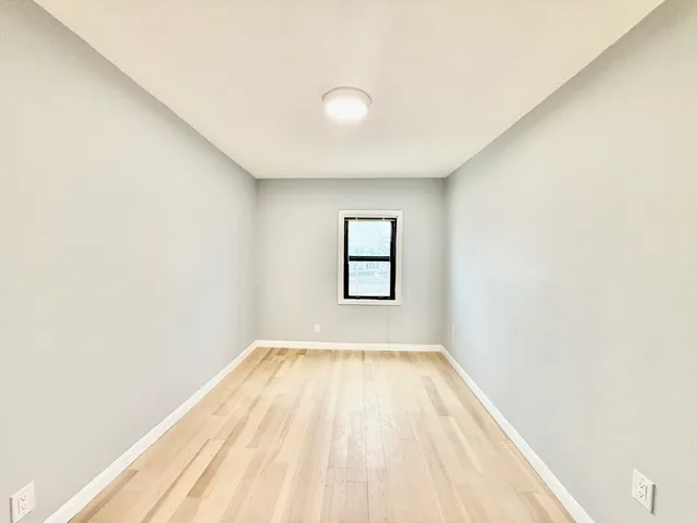 a view of a big room with wooden floor and windows