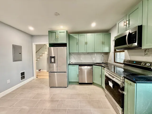a kitchen with stainless steel appliances granite countertop a refrigerator and a stove top oven