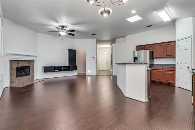a kitchen with stainless steel appliances a sink dishwasher stove and microwave with wooden floor