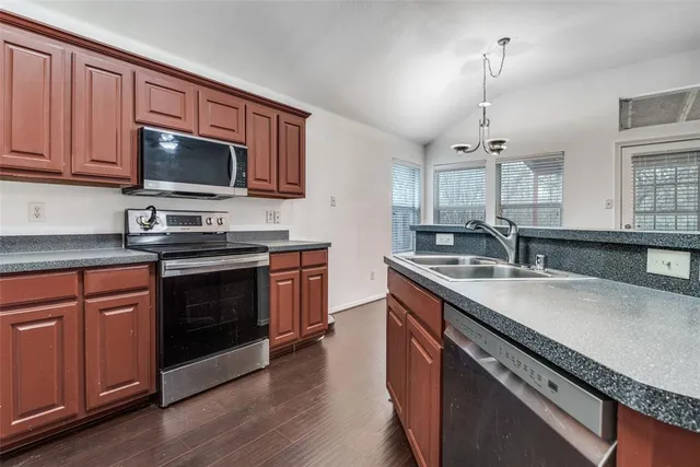 a kitchen with stainless steel appliances granite countertop a refrigerator and a sink