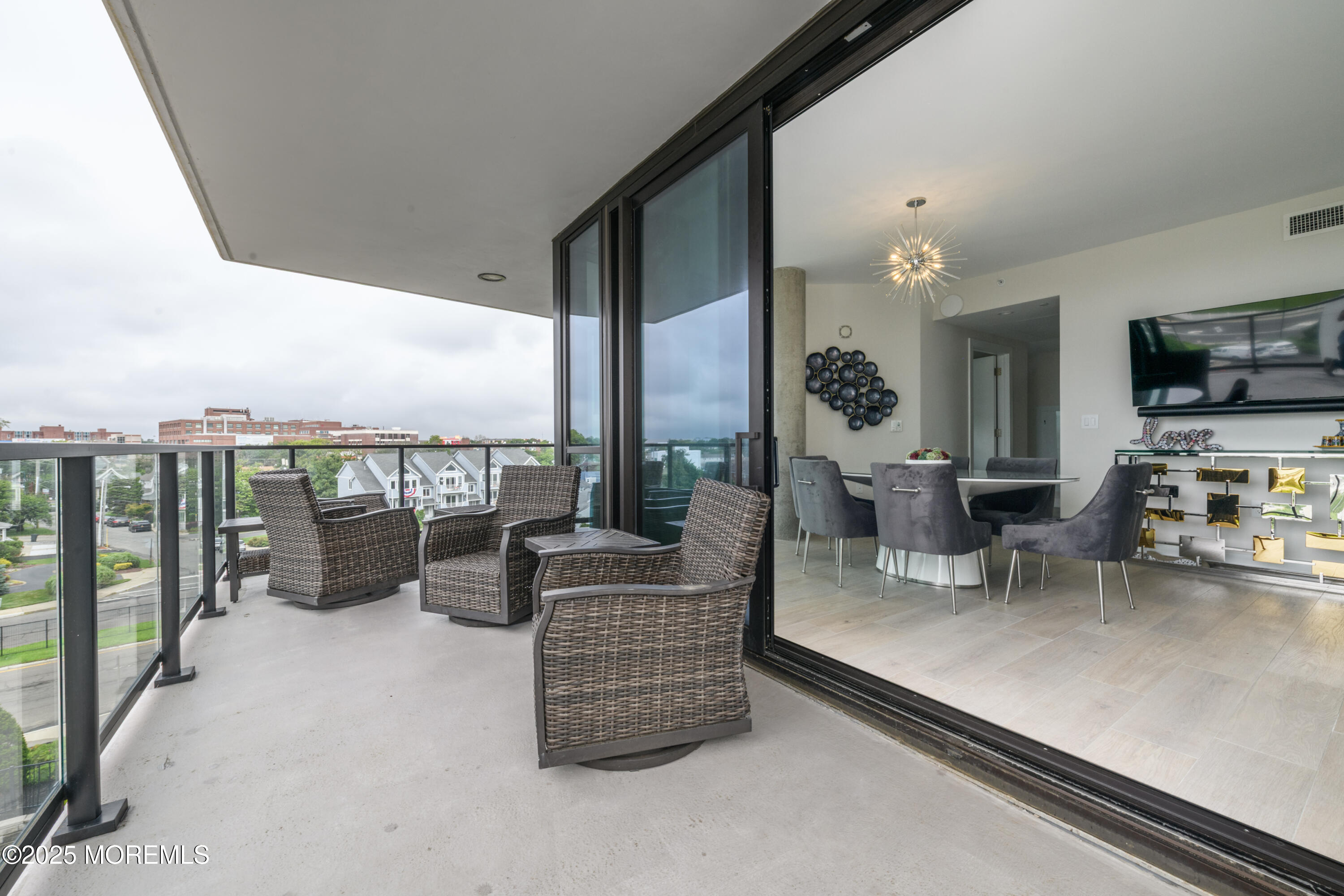350 Ocean Avenue, Unit 403 Long Branch, NJ 07740 - Photo 18 of 23 a living room with furniture a flat screen tv and a floor to ceiling window
