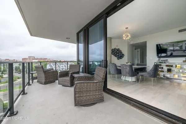 a living room with furniture a flat screen tv and a floor to ceiling window