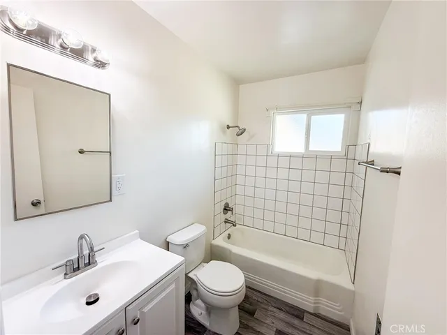 a bathroom with a bathtub shower sink mirror vanity and toilet