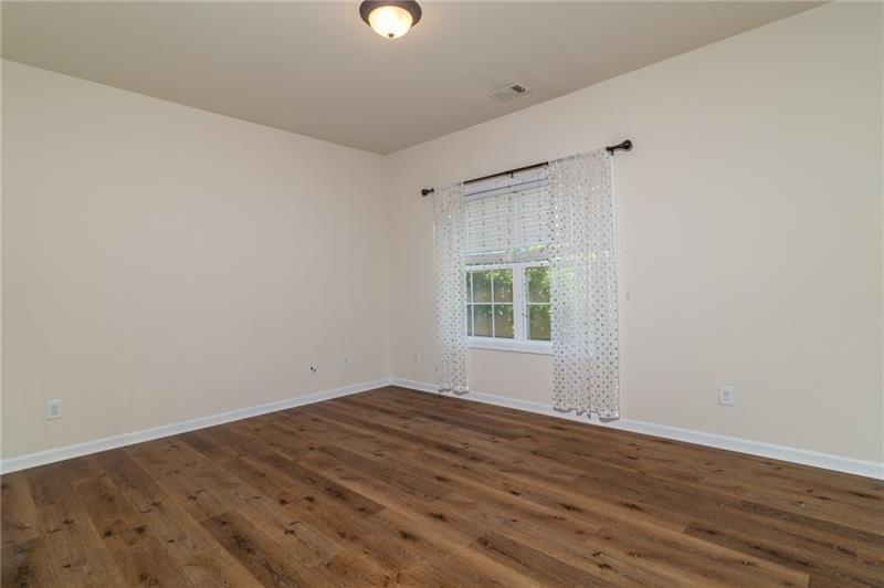 206 Sawtooth Court Canton, GA 30114 - Photo 14 of 42 an empty room with wooden floor and windows