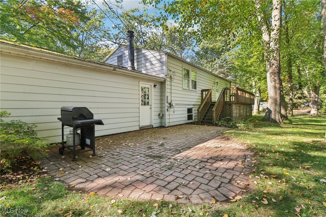 1625 Travers Road Madison, OH 44057 - Photo 4 of 41 Rear view of house with a patio, a yard, and stairway