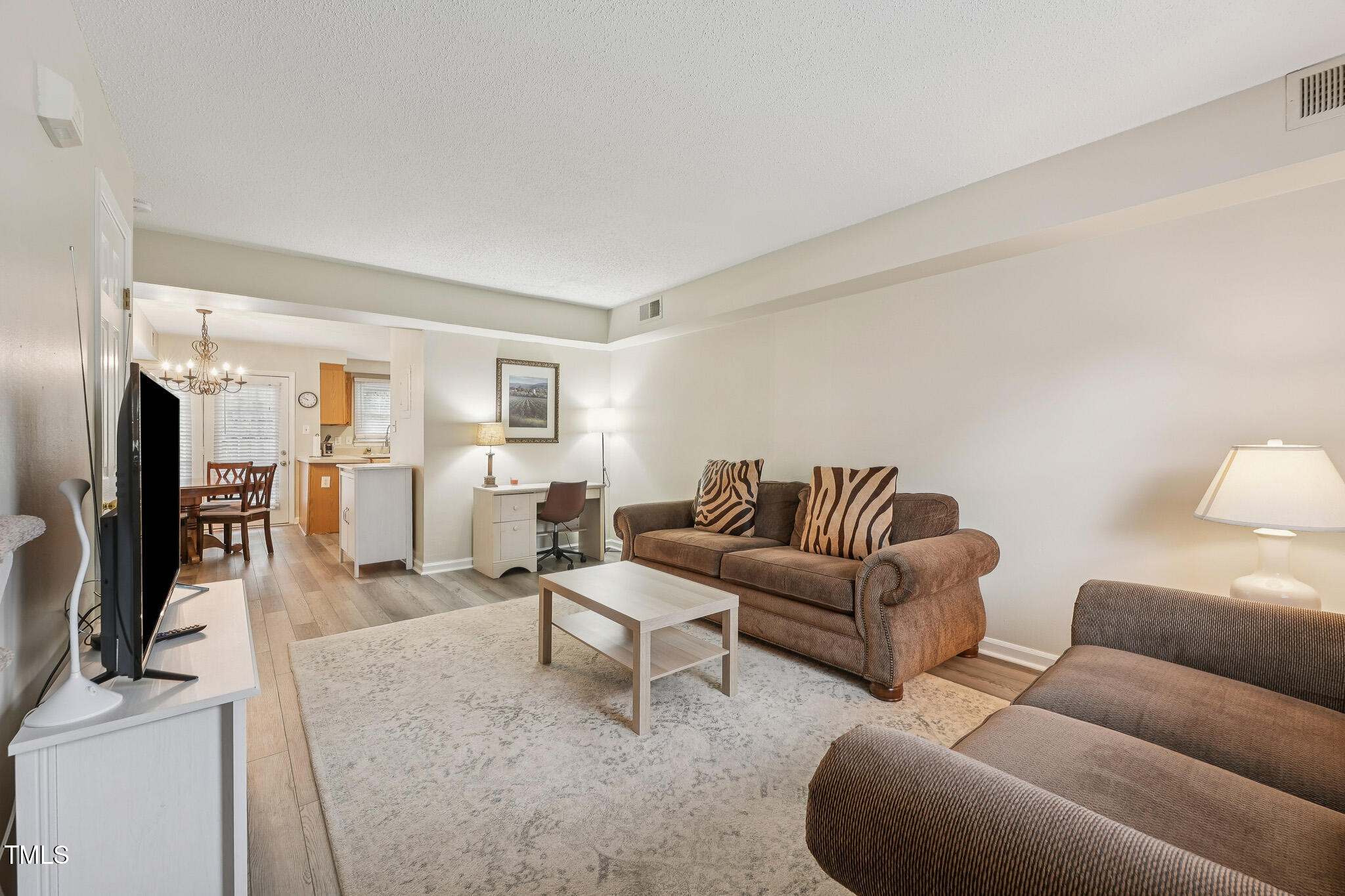 149 Jones Franklin Road, Unit A Raleigh, NC 27606 - Photo 9 of 21 a living room with furniture white walls and a flat screen tv