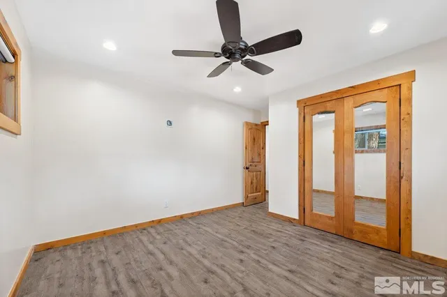 a view of a livingroom with a ceiling fan & wooden floor
