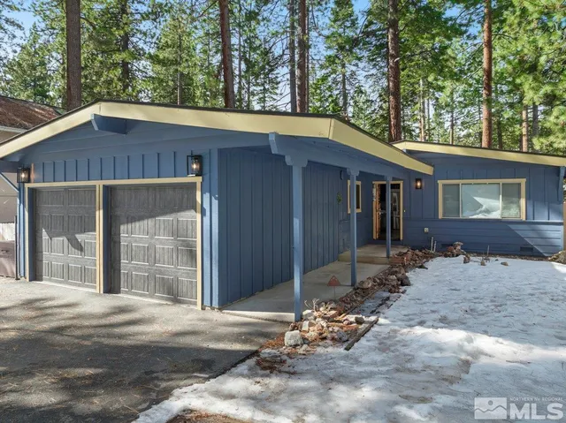 a view of a house with a yard and large tree