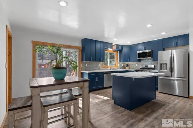 a kitchen with kitchen island granite countertop wooden floors appliances and furniture