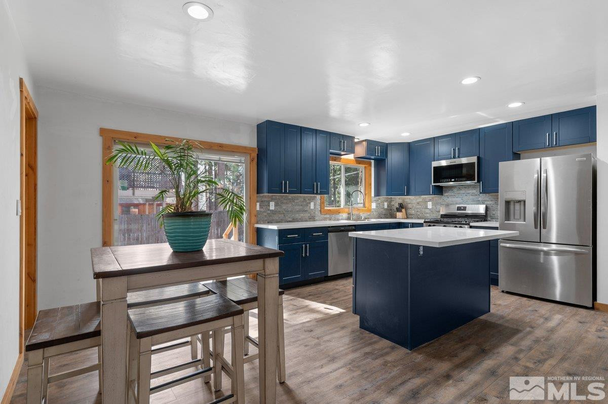 190 Meadow Drive Stateline, NV 89449 - Photo 3 of 26 a kitchen with kitchen island granite countertop wooden floors appliances and furniture