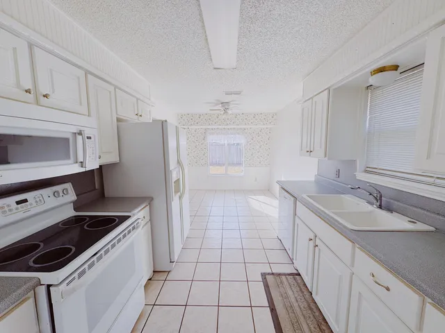 a kitchen with a sink stove and cabinets