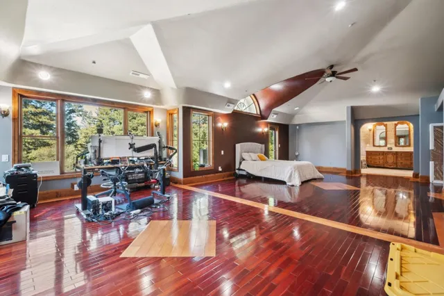 a living room with lots of furniture wooden floor and large windows