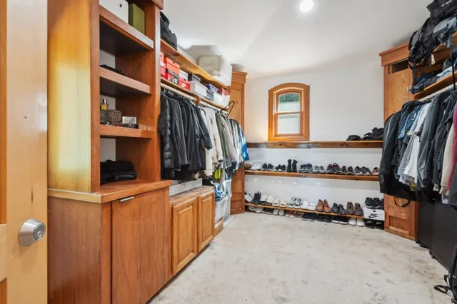 a view of walk in closet with clothes and shoes