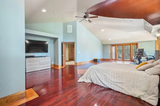 a bedroom with a bed and wooden floor
