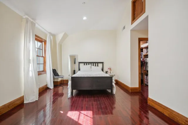 a view of a bedroom with wooden floor and a window