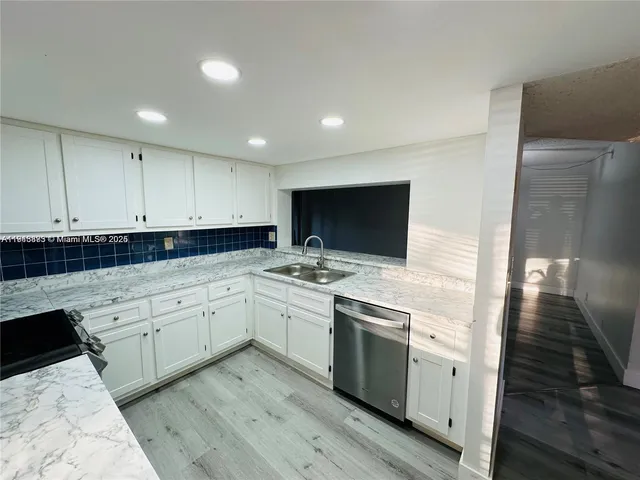 a kitchen with a sink cabinets and stainless steel appliances