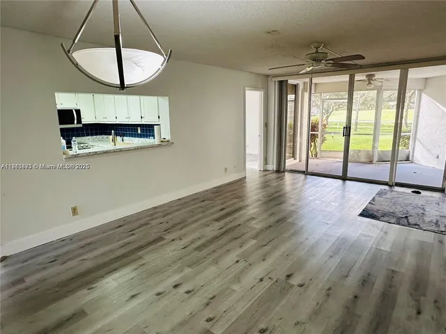 a view of a livingroom with wooden floor and a large window