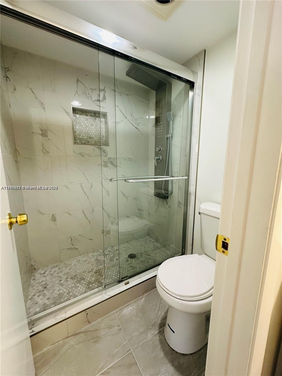 9501 Seagrape Drive, Unit 101 Davie, FL 33324 - Photo 6 of 11 a bathroom with a shower and a toilet