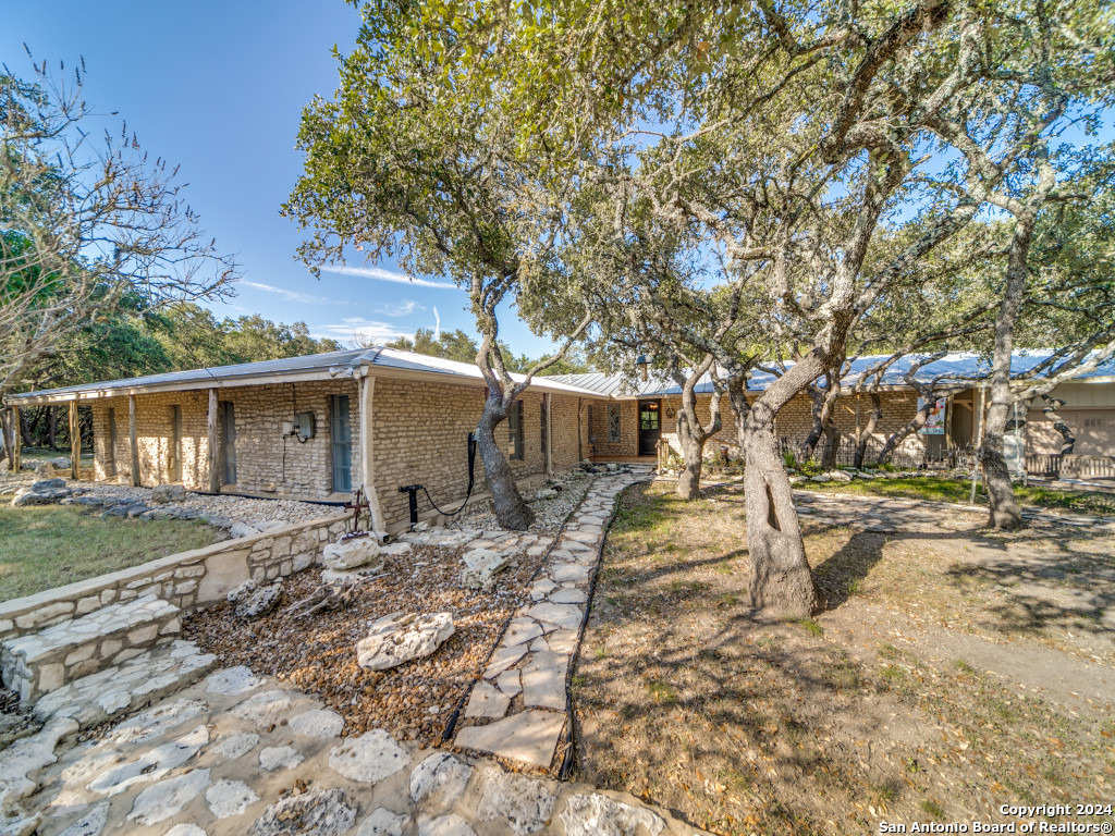a backyard of a house with wooden fence and large trees