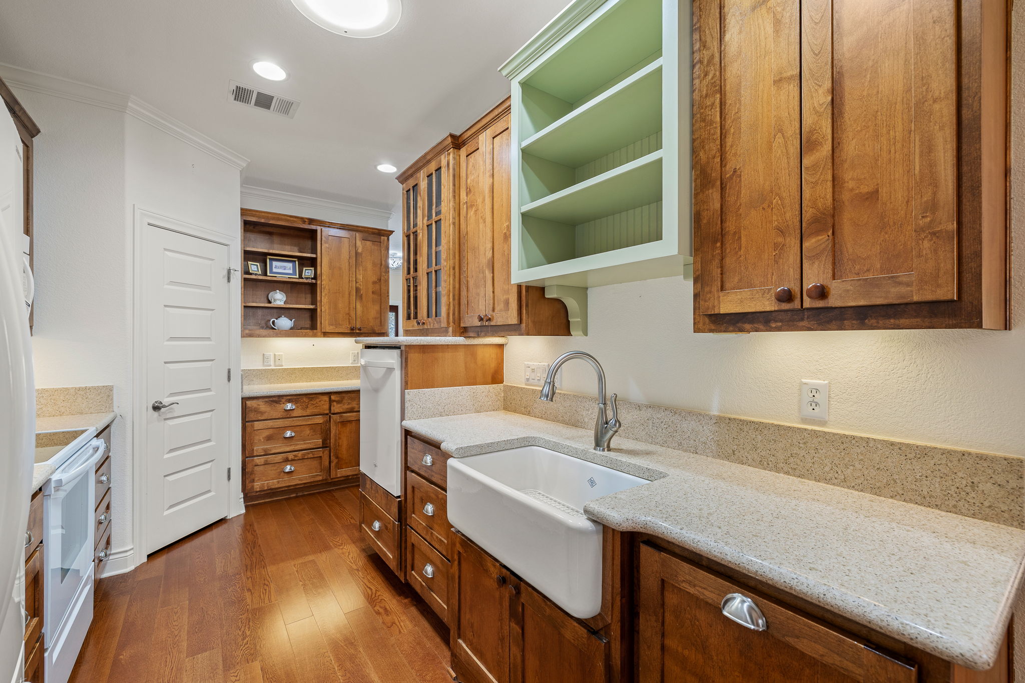 5201 Big Spring Street Georgetown, TX 78633 - Photo 11 of 26 Kitchen with open shelves, wood finish cabinetry, glass insert cabinets, light stone counters, and recessed lighting