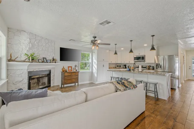 a living room with furniture a fireplace and a flat screen tv