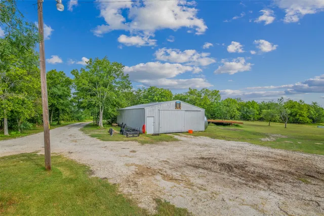 a view of a chair and table in backyard of the house