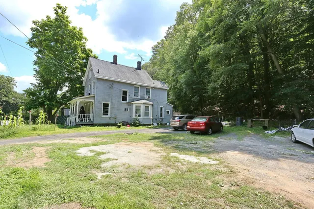 a view of a house with a yard and sitting area