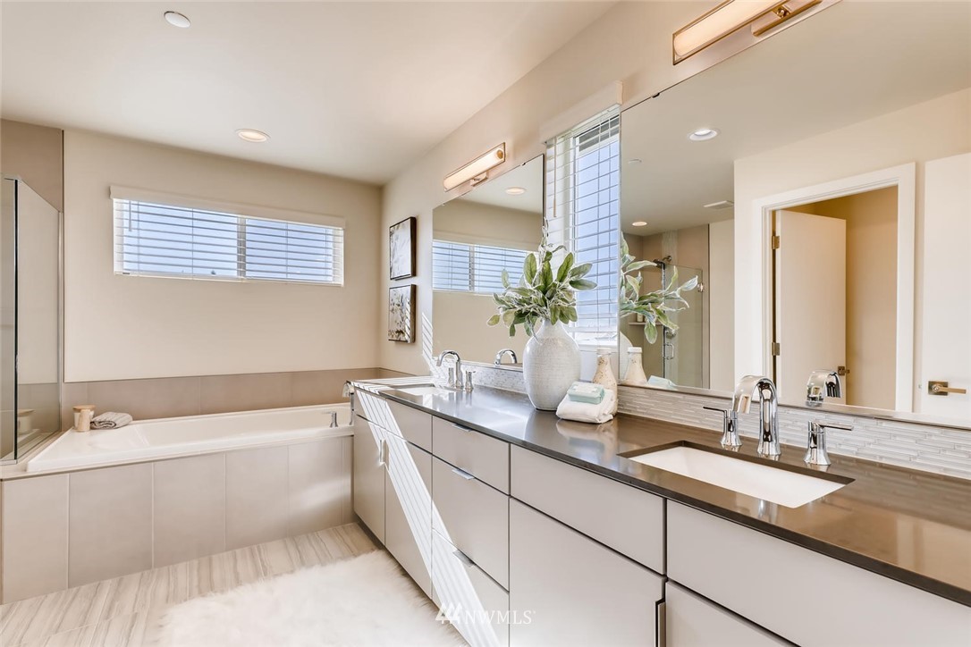 4427 232nd Place Southeast, Unit 20 Bothell, WA 98021 - Photo 17 of 28 a bathroom with a granite countertop tub a double vanity sink and a large mirror