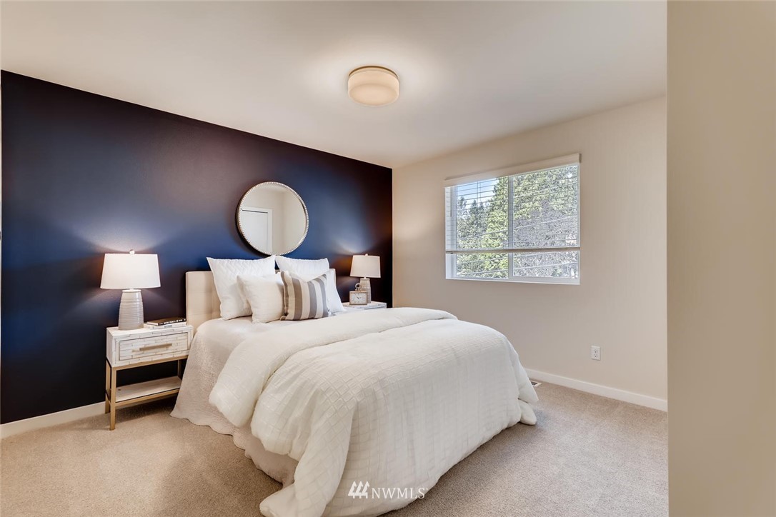 4427 232nd Place Southeast, Unit 20 Bothell, WA 98021 - Photo 19 of 28 a bedroom with a bed and a lamp next to a window