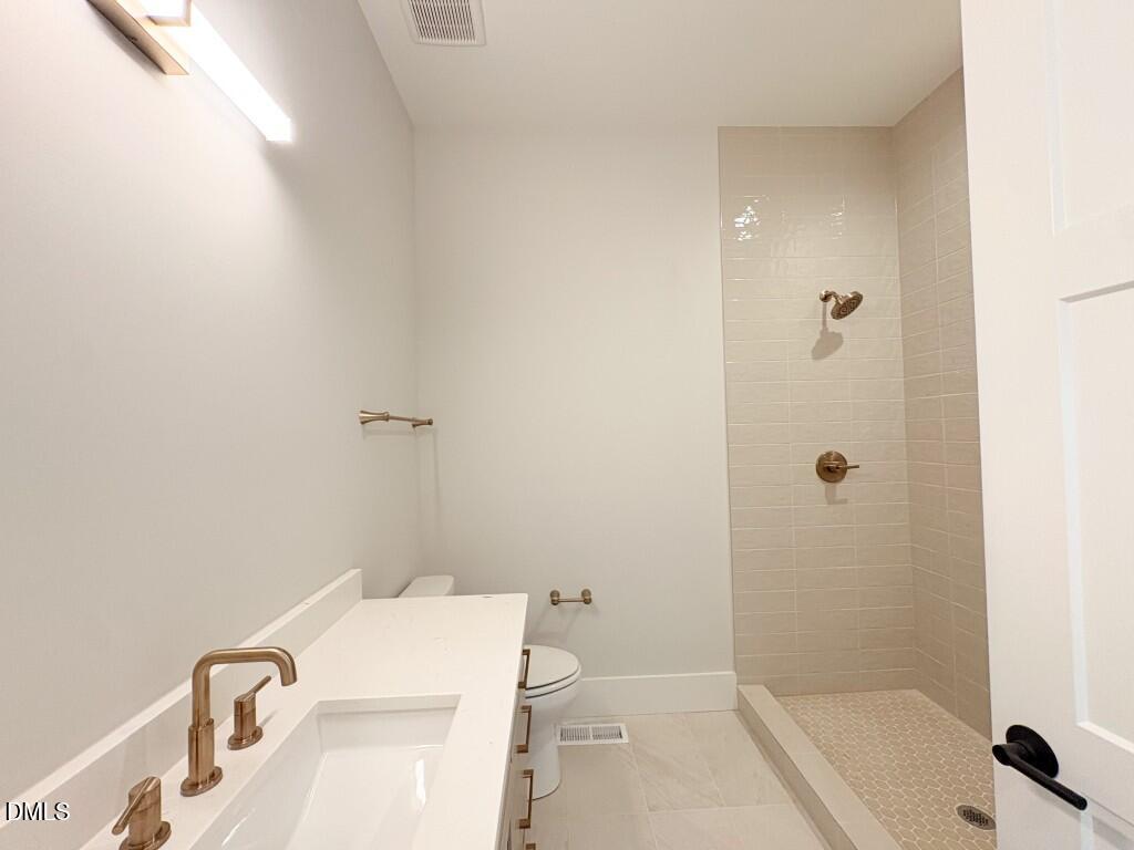 5848 Carriage Drive Raleigh, NC 27603 - Photo 10 of 28 a bathroom with a sink a toilet and shower