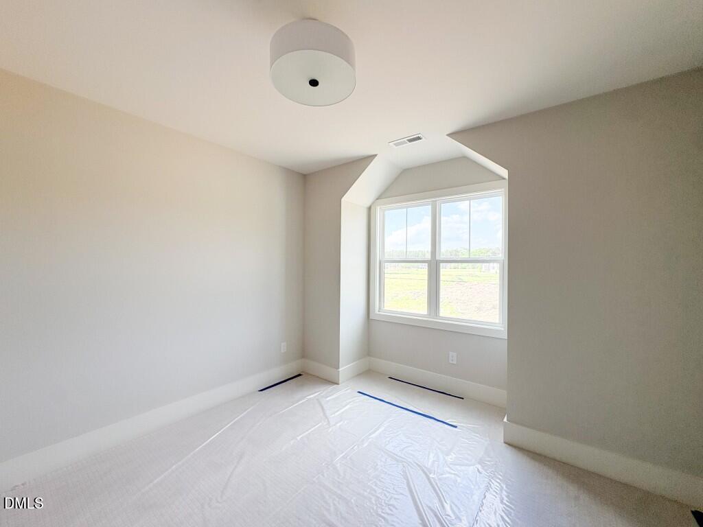 5848 Carriage Drive Raleigh, NC 27603 - Photo 15 of 28 an empty room with a window and a chandelier fan