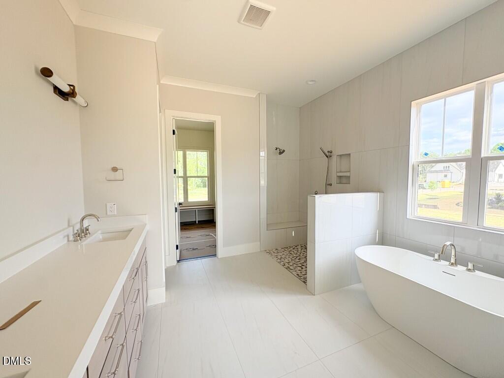 5848 Carriage Drive Raleigh, NC 27603 - Photo 7 of 28 a bathroom with a tub a sink and a large mirror