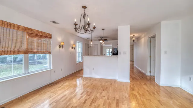 a view of a big room with wooden floor and a kitchen