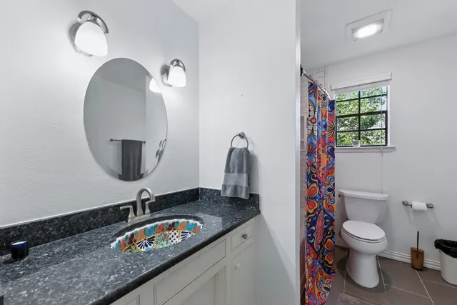a bathroom with a granite countertop sink and a mirror