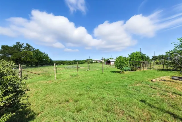a view of a green field with wooden fence