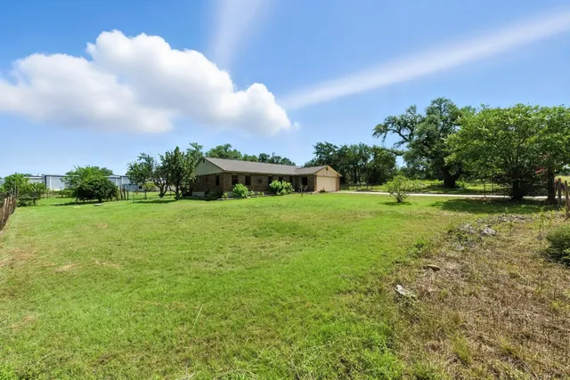 a view of a green field with wooden fence