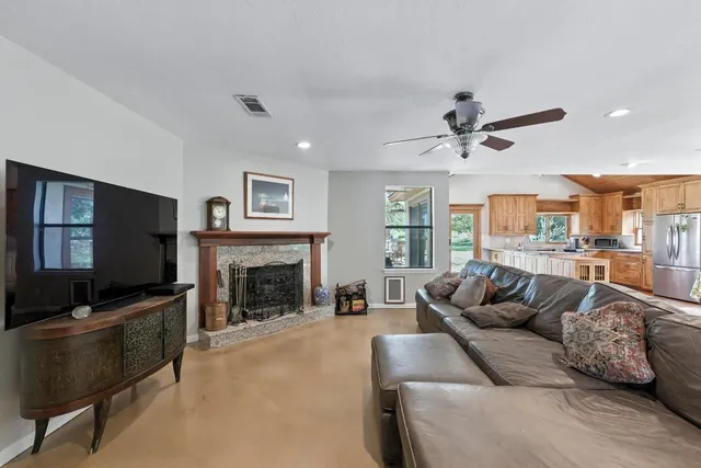 a living room with furniture a fireplace and a flat screen tv