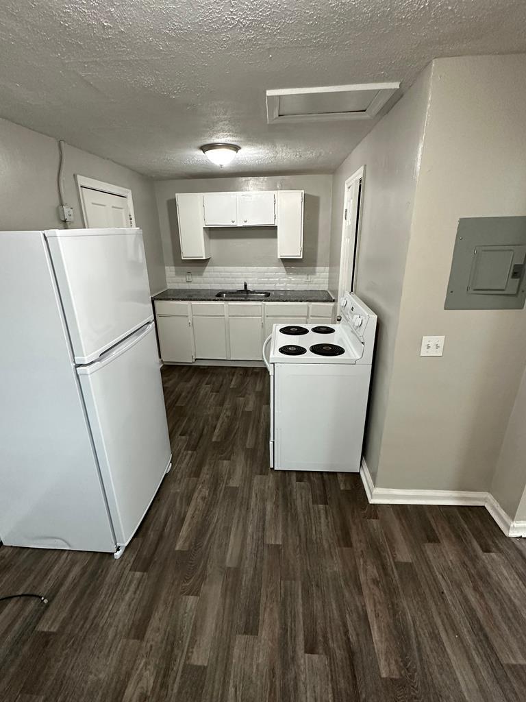 475 Mellon Street Columbus, GA 31903 - Photo 2 of 7 a kitchen with wooden floors and white appliances