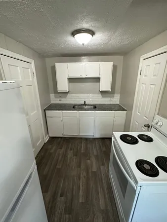 a kitchen with a sink and wooden floor