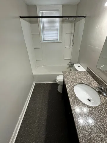 a bathroom with a granite countertop sink toilet and shower